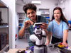 Context shot of two engineers in a lab attaching a camera to a robotic arm powered by an Arduino VENTUNO Q, testing hardware together.