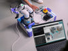 Top-down view of the Arduino VENTUNO Q-powered robotic arm on a desk, with a laptop displaying live point-cloud mapping software nearby.