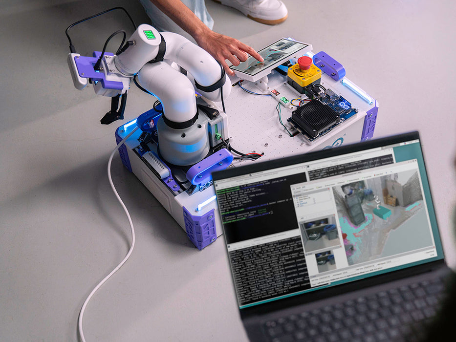 Top-down view of the Arduino VENTUNO Q-powered robotic arm on a desk, with a laptop displaying live point-cloud mapping software nearby.